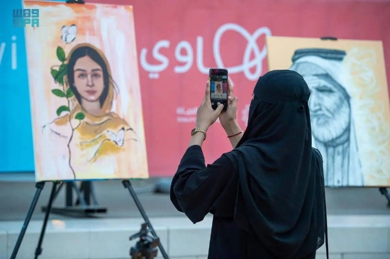 زائرة تلتقط صورة لإحدى اللوحات المعروضة