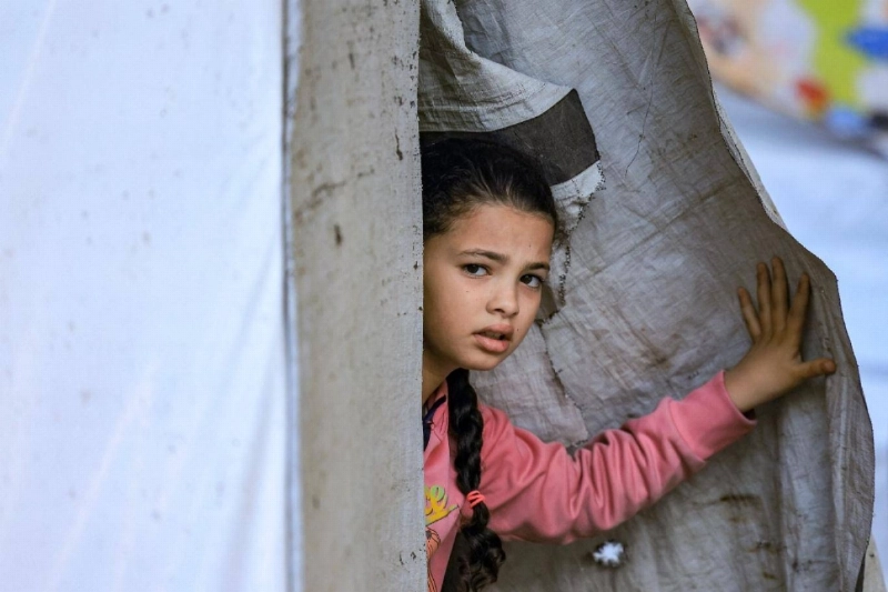 طفلة فلسطينية تحتمي من القصف