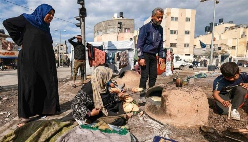 فلسطينيون في الشارع يجهزون طعامهم من دقيق الأونروا (مكة)