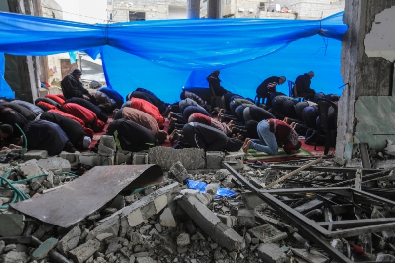 فلسطينيون يصلون بجانب الدمار (د ب أ)