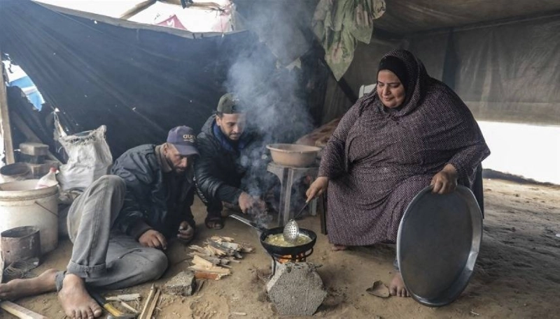 أسرة فلسطينية تجهز طعامها في خيمة (مكة)