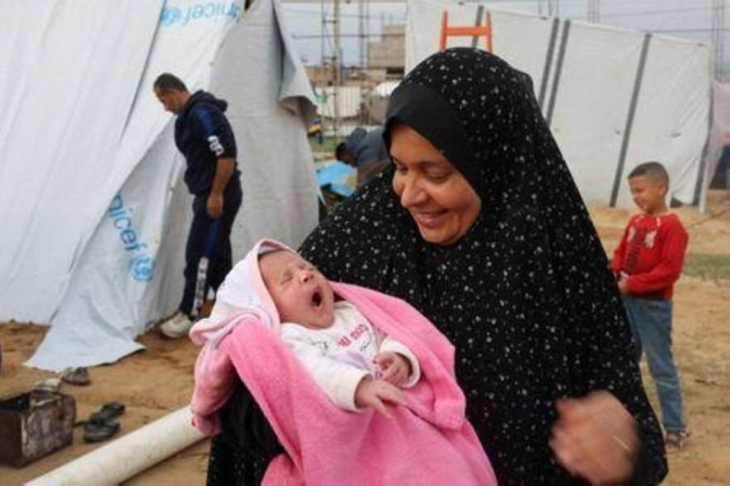 جدة تحمل طفلة ماتت أمها داخل مخيمات غزة