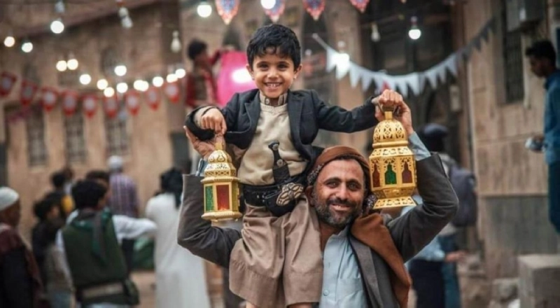 أب يمني يحمل ابنه ويبتسمان رغم المآسي (مكة)