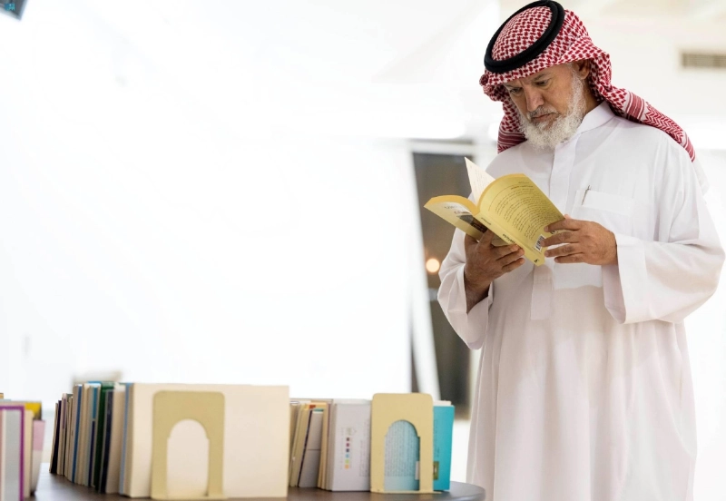 زائر يطلع على أحد الكتب بالمعرض (مكة)