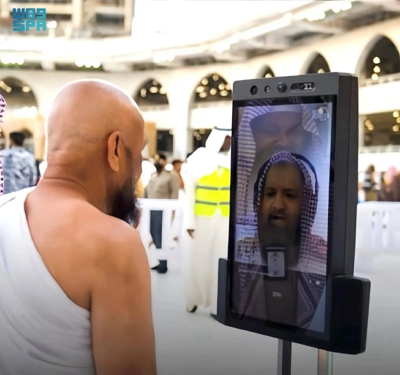 معتمر يتلقى توجيها من أحد الروبوتات (مكة)