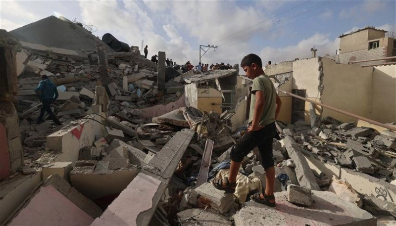 طفل غزاوي يقف على آثار بيتهم المدمر (مكة)