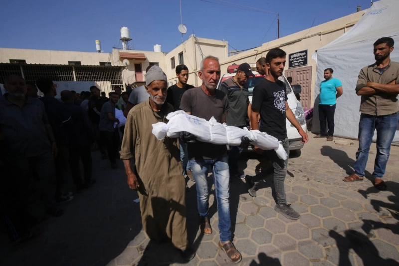 غزاوي يحمل ابنه الشهيد بعد مجزرة المخيمات (د ب أ)