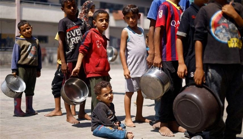 أطفال غزاويون ينتظرون دورهم للحصول على الطعام (مكة)