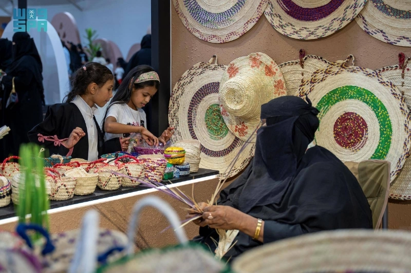 حرفية تعرض منتجات مصنوعة من سعف النخيل