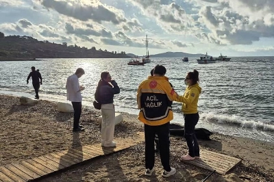 Emergency officials standing next to the body of a migrant as Turkish coastguard boats (background) search for victims off the coast of Bodrum, following the capsize of a dinghy in the Aegean Sea. Demiroren News Agency/AFP Emergency officials standing next to the body of a migrant as Turkish coastguard boats (background) search for victims off the coast of Bodrum, following the capsize of a dinghy in the Aegean Sea. Demiroren News Agency/AFP