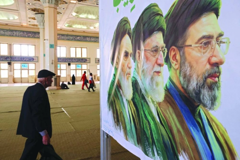 An Iranian man walks past an image of former and the current Iranian supreme leaders, Ayatollah Ruhollah Khomeini (L), Ali Khamenei, and his son, the current leader Mojtaba Khamenei (R), in Tehran yesterday. (AFP)
An Iranian man walks past an image of former and the current Iranian supreme leaders, Ayatollah Ruhollah Khomeini (L), Ali Khamenei, and his son, the current leader Mojtaba Khamenei (R), in Tehran yesterday. (AFP)