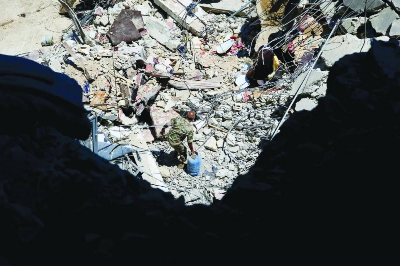 A Lebanese soldier removes gas canisters from the rubble of a building hit by an Israeli airstrike in the southern port city of Tyre yesterday. (AFP) A Lebanese soldier removes gas canisters from the rubble of a building hit by an Israeli airstrike in the southern port city of Tyre yesterday. (AFP)