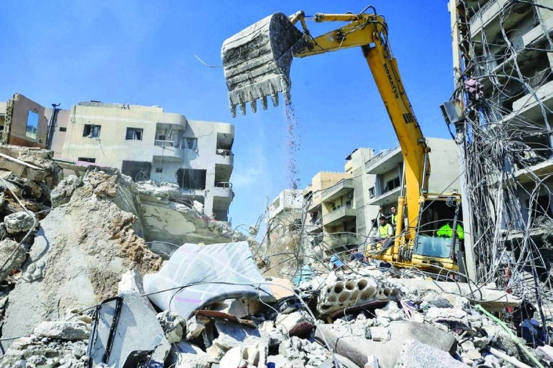 An excavator clears the rubble of a building as rescuers search for victims after an Israeli airstrike that struck near a hospital in Tyre. (AFP)
An excavator clears the rubble of a building as rescuers search for victims after an Israeli airstrike that struck near a hospital in Tyre. (AFP)