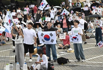 Korean protesters wave the national flags outside a vote-counting centre in Seoul Wednesday, to call for a rerun of the local elections due to a shortage of ballot papers. (AFP) Korean protesters wave the national flags outside a vote-counting centre in Seoul Wednesday, to call for a rerun of the local elections due to a shortage of ballot papers. (AFP)