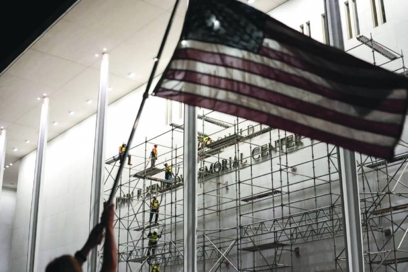 A person holds up a U.S. national flag as workers prepare scaffolding ahead of removing the lettering referencing U.S. President Donald Trump from the facade of the John F. Kennedy Center for the Performing Arts, after a federal judge ordered that President Trump's name be removed from the building in Washington, D.C., U.S., June 12, 2026. REUTERS A person holds up a U.S. national flag as workers prepare scaffolding ahead of removing the lettering referencing U.S. President Donald Trump from the facade of the John F. Kennedy Center for the Performing Arts, after a federal judge ordered that President Trump's name be removed from the building in Washington, D.C., U.S., June 12, 2026. REUTERS