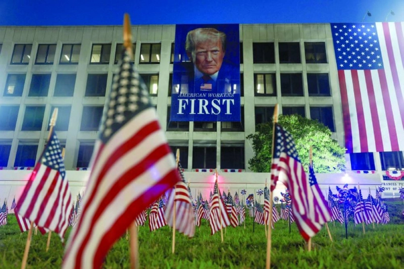 American flags are planted in the ground in front of a banner of President Donald Trump, hanging from the US Department of Labour building, ahead of July 4th festivities. (AFP)
American flags are planted in the ground in front of a banner of President Donald Trump, hanging from the US Department of Labour building, ahead of July 4th festivities. (AFP)