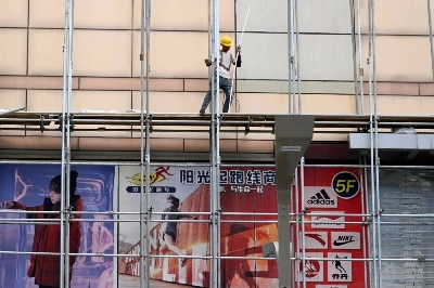 A worker walks on scaffolding outside a mall in Beijing on Tuesday. At 4.3%, gross domestic product growth in April-June eased from the first quarter's 5.0%, landing below the lower end of China's 4.5% to 5.0% full-year target. A worker walks on scaffolding outside a mall in Beijing on Tuesday. At 4.3%, gross domestic product growth in April-June eased from the first quarter's 5.0%, landing below the lower end of China's 4.5% to 5.0% full-year target.