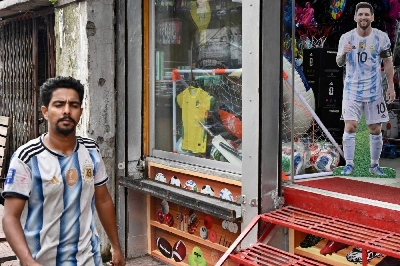 A man wearing Argentina's football jersey walks past a life-size cut-out of Argentina's forward #10 Lionel Messi A man wearing Argentina's football jersey walks past a life-size cut-out of Argentina's forward #10 Lionel Messi