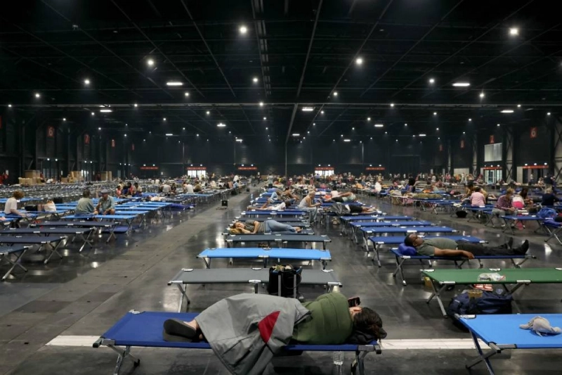 TOPSHOT - Local residents rest at the Parc des Expositions de Bordeaux after being evacuated due to wildfires in the region, in Bordeaux, on July 25, 2026. France and Spain evacuated more than 160,000 people as unprecedented forest fires ravaged areas on July 25 near Madrid and Bordeaux, a French city flanked by tourist havens and world-renowned vineyards. Authorities ordered the evacuation of towns near Bordeaux "as a precaution" against the approaching inferno, while traffic information website Bison Fute urged drivers to avoid roads in the area to free up access for emergency services. (Photo by ALAIN JOCARD / AFP) TOPSHOT - Local residents rest at the Parc des Expositions de Bordeaux after being evacuated due to wildfires in the region, in Bordeaux, on July 25, 2026. France and Spain evacuated more than 160,000 people as unprecedented forest fires ravaged areas on July 25 near Madrid and Bordeaux, a French city flanked by tourist havens and world-renowned vineyards. Authorities ordered the evacuation of towns near Bordeaux "as a precaution" against the approaching inferno, while traffic information website Bison Fute urged drivers to avoid roads in the area to free up access for emergency services. (Photo by ALAIN JOCARD / AFP)