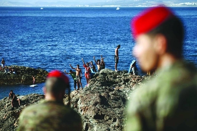 Members of the Spanish Army’s ‘Regulares’ infantry forces watch a group of migrants near the border post of the Spanish enclave of Ceuta on Sunday. (AFP)
Members of the Spanish Army’s ‘Regulares’ infantry forces watch a group of migrants near the border post of the Spanish enclave of Ceuta on Sunday. (AFP)
