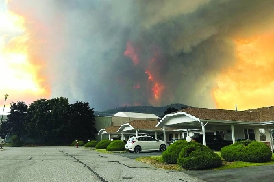 Smoke rises from the Bald Range wildfire over a residential street in British Columbia on Friday. (Reuters)
Smoke rises from the Bald Range wildfire over a residential street in British Columbia on Friday. (Reuters)