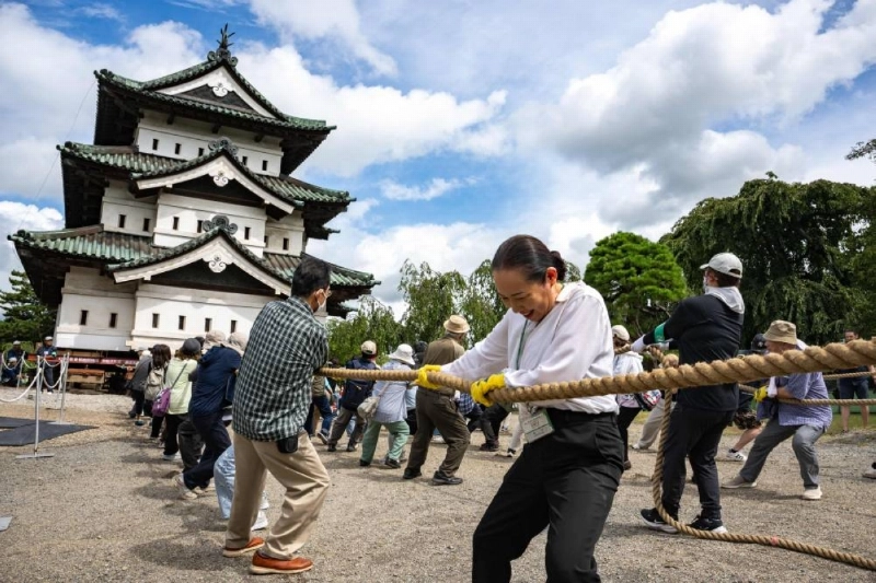 Participants pull Hirosaki Castle using ropes to its original position following repair works in Hirosaki, Aomori Prefecture, yesterday. (AFP) Participants pull Hirosaki Castle using ropes to its original position following repair works in Hirosaki, Aomori Prefecture, yesterday. (AFP)
