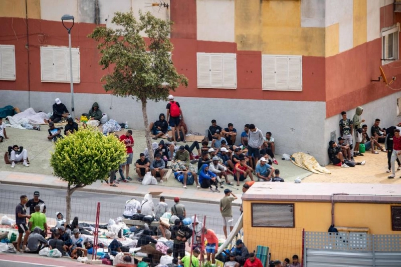 Migrants wait on the sidewalk in Loma Colmenar district of Ceuta yesterday. (AFP) Migrants wait on the sidewalk in Loma Colmenar district of Ceuta yesterday. (AFP)