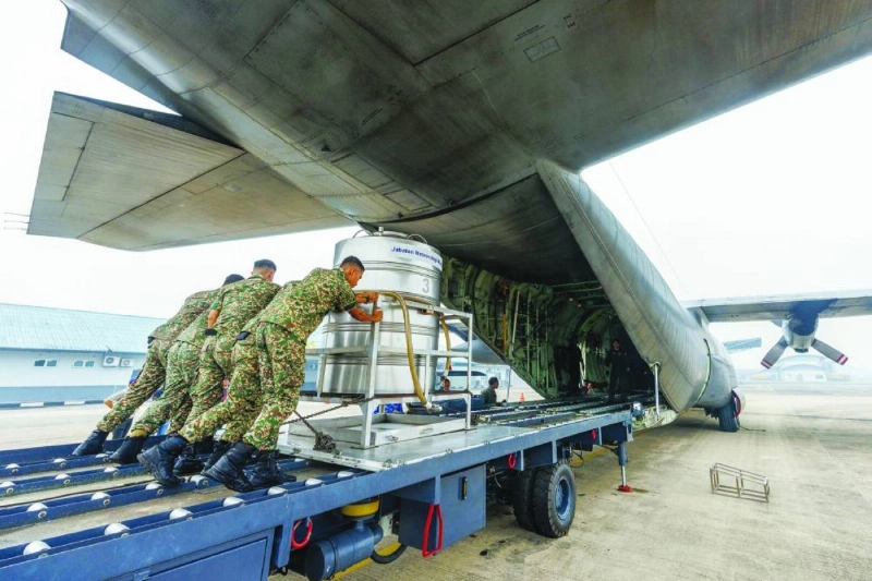 Members of the Royal Malaysian Air Force push a cloud-seeding tank into a C-130 aircraft at the air force base in Kuching, the capital of Sarawak state on the island of Borneo, on Thursday. (AFP) Members of the Royal Malaysian Air Force push a cloud-seeding tank into a C-130 aircraft at the air force base in Kuching, the capital of Sarawak state on the island of Borneo, on Thursday. (AFP)