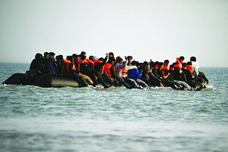 FILE PHOTO: Migrants wave after boarding an inflatable dinghy before leaving the coast of northern France in an attempt to cross the English Channel to reach Britain, from the beach of Petit-Fort-Philippe in Gravelines, near Calais, France, May 23, 2026. REUTERS/Dylan Martinez/File Photo FILE PHOTO: Migrants wave after boarding an inflatable dinghy before leaving the coast of northern France in an attempt to cross the English Channel to reach Britain, from the beach of Petit-Fort-Philippe in Gravelines, near Calais, France, May 23, 2026. REUTERS/Dylan Martinez/File Photo