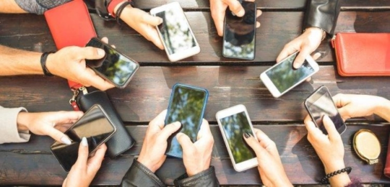 People group having addicted fun together using smartphones - Detail of hands sharing content on social network with mobile smart phones - Technology concept with millennials online with cellphones