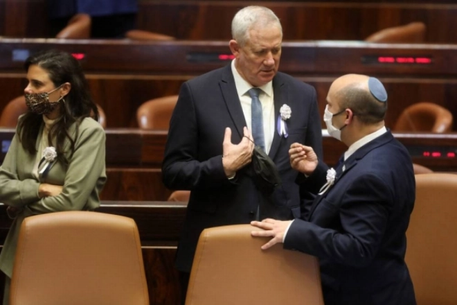 Israel's Defence Minister Benny Gantz (L) and Prime Minister Naftali Bennett speak to each other at a Knesset (parliament) meeting during which Isaac Herzog, a veteran of Israel's left-wing Labor party, was sworn in as the Jewish state's 11th president, replacing Reuvin Rivlin, in Jerusalem, on July 7, 2020. (Photo by Gil COHEN-MAGEN / AFP)