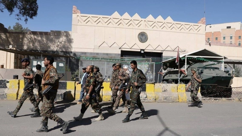 Des Houtis armés faisant entendre le bruit de leurs bottes devant le consulat américain à Sanaa