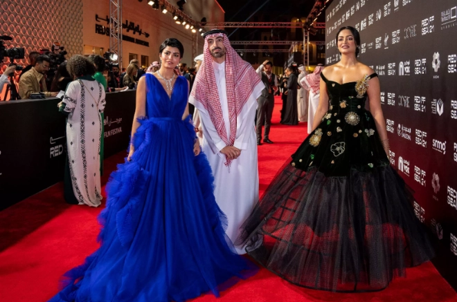 Les actrices saoudiennes Mila Al-Zahrani (g.) et Fay Fouad (d.) et le président du festival Mohamed Al-Turki sur le tapis rouge lors de la cérémonie d’ouverture du Red Sea Festival.