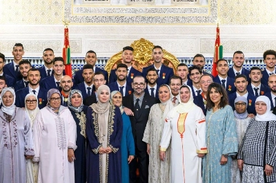 Le Roi Mohammed VI prenant la photo de famille avec les joueurs de l'Équipe nationale, leur coach et le Président de la FRMF ainsi que les mamans de ces joueurs, après l'exploit historique réalisé par l'Équipe nationale au Mondial 2022.