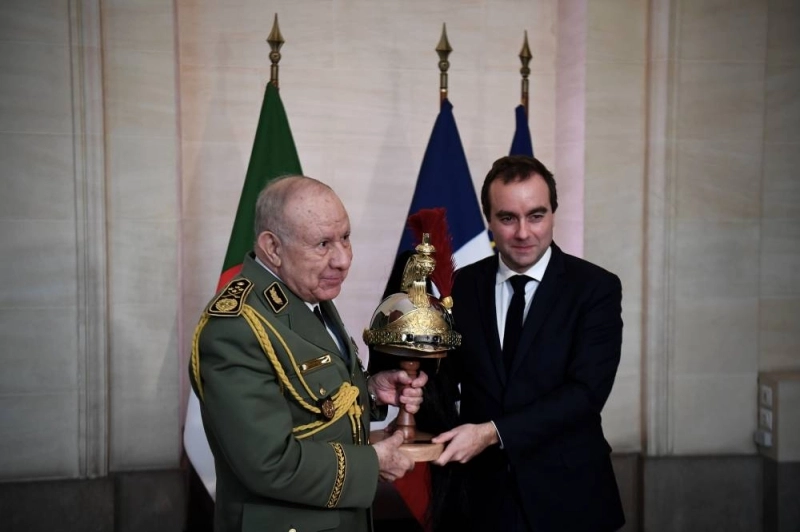 Le chef d'Etat major de l'armée algérienne recevant le casque de garde des mains du ministre français de la défense. (AFP)