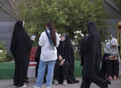 Une jeune iranienne non-voilée et ses amies portant le hijab à une foire du livre organisée à la Grande Mosquée de Téhéran le 14 mai 2023.