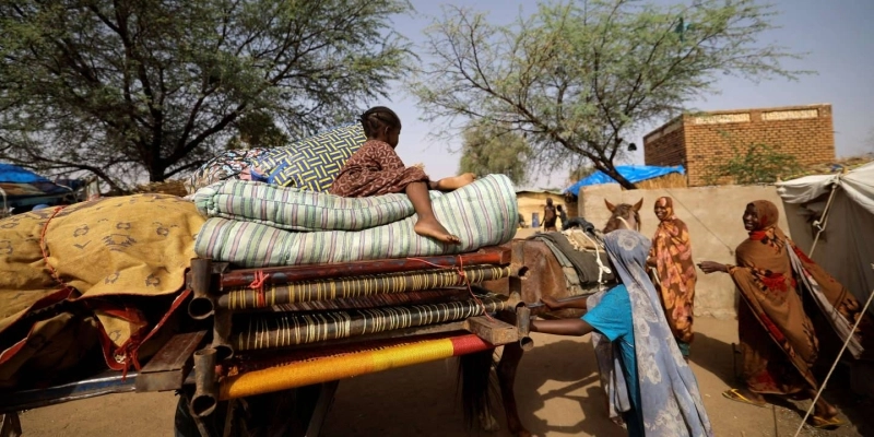 A Sudanese refugee girl, who fled the violence in Sudan's Darfur region and newly arrived, sits on her family's belongings outside the house of a Chadian family, where they take refuge, near the border between Sudan and Chad in Koufroun, Chad, May 14, 2023. REUTERS/Zohra Bensemra