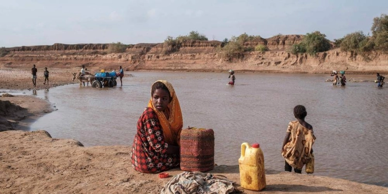 A girl looks on as she sits on the shore of the Shabelle river in the city of Gode, Ethiopia, on April 8, 2022. - The worst drought to hit the Horn of Africa for 40 years is pushing 20 million people towards starvation, according to the UN, destroying an age-old way of life and leaving many children suffering from severe malnutrition as it rips families apart. (Photo by EDUARDO SOTERAS / AFP)