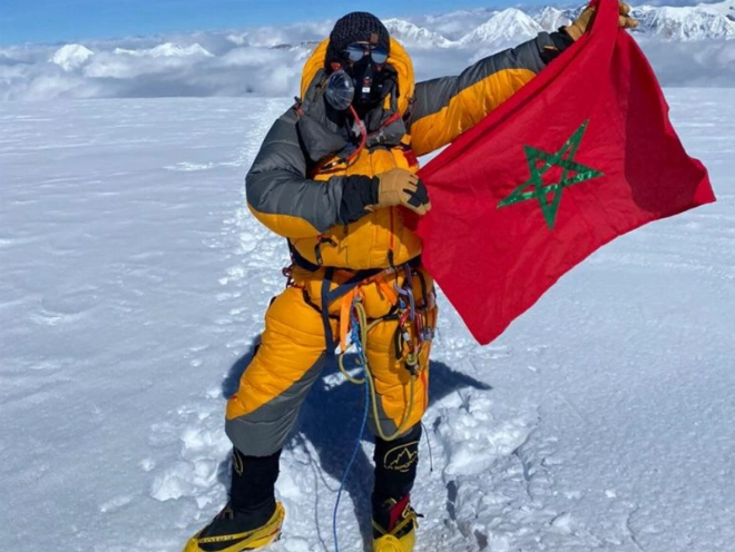 Nawal Sfendla hissant le drapeau marocain au Mont Manaslu au Népal.