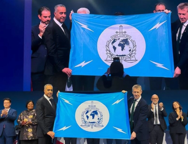 Abdellatif Hammouchi brandissant le drapeau d'Interpol avec le patron de cette organisation