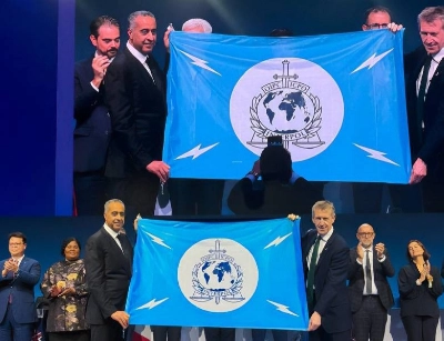 Abdellatif Hammouchi recevant le drapeau d'Interpol des mains du ministre britannique de la Sécurité, Dan Jarvis