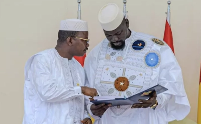 Le président du Conseil national de transition, Dr. Dansa Kourouma (gauche) remet au président guinéen Mamadi Doumbouya (droite) le projet de nouvelle Constitution guinéenne, le 26 juin 2025 à Conakry