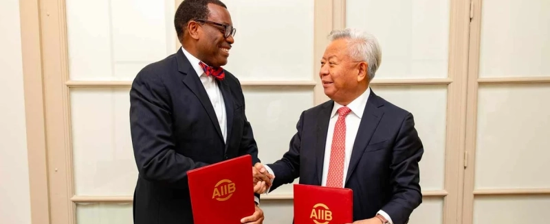 Le président du Groupe de la Banque africaine de développement, Akinwumi Adesina (à gauche), et le président de l’AIIB, Jin Liqun, se serrent la main après avoir signé un protocole d’accord renouvelant la collaboration entre leurs institutions pour un développement économique durable en Afrique.