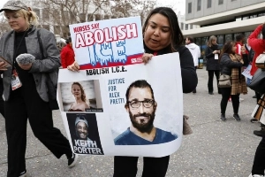 A nurse holds a placard during a protest organized by the California Nursing Association in Oakland on January 27, 2026. —EPA