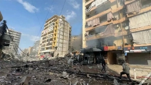 People walk through rubble in front of a strike-damaged building in Beirut, Lebanon, on Wednesday.