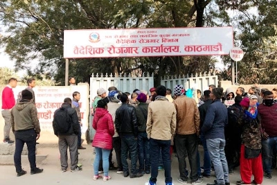 फाइल - विदेशी कार्यालयमा विदेशी कामदारहरूको भीडमा कादुको कार्यालय बाहिर पर्खिरहेका कर्मचारीहरू।