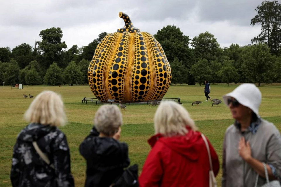 FILE PHOTO: People look at Japanese artist Yayoi Kusama's sculpture 'Pumpkin' in Kensington Palace Gardens in London, Britain, July 9, 2024. REUTERS/Hollie Adams/File Photo