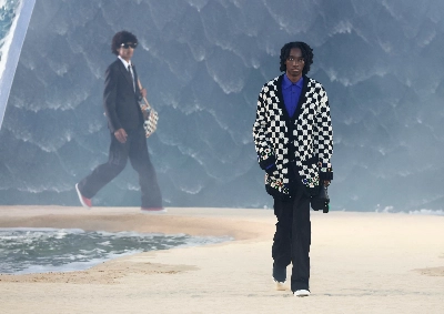 Louis Vuitton designer Pharrell Williams uses giant tidal wave set as backdrop for Paris fashion show