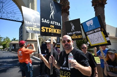 Members of the Writers Guild of America and the Screen Actors Guild take part in a picket line outside Paramount Studios in Hollywood, California, on Thursday.  Members of the Writers Guild of America and the Screen Actors Guild take part in a picket line outside Paramount Studios in Hollywood, California, on Thursday.