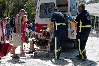 Medics help a woman who had passed out from the heat in Athens, Greece, on Thursday. | Bloomberg